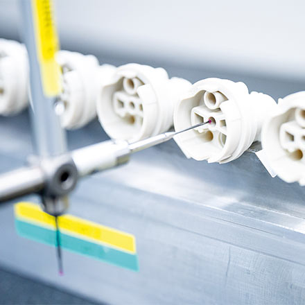 White polymer components undergoing precision inline measurement – zero-defect quality control