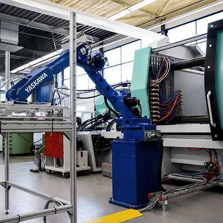 Industrial robot at an injection moulding machine – high-volume series production